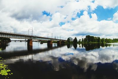 Bridge over river against cloudy sky