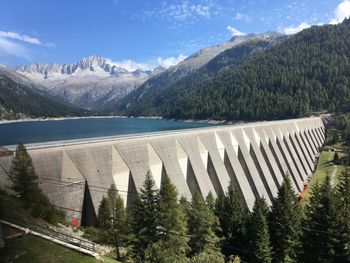 Scenic view of dam and mountains against sky