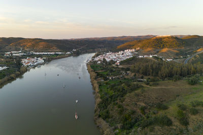 Aerial drone view of sanlucar de guadiana in spain and alcoutim in portugal with sail boats