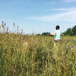 Full length of woman standing on field against sky