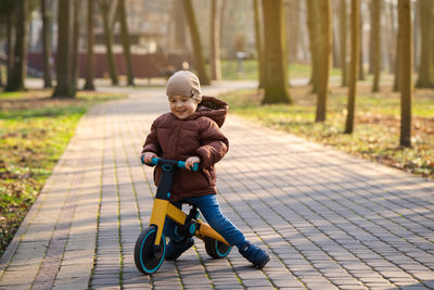 Portrait of boy riding bicycle on footpath