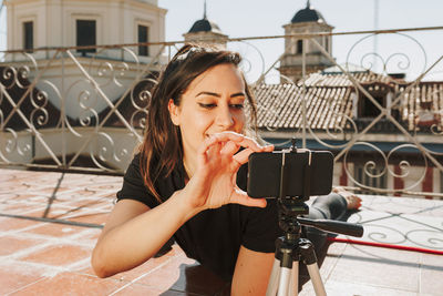 Young sporty fit woman coach doing online lessons through video call on her mobile phone