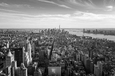 Aerial view of cityscape against cloudy sky