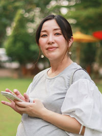 Portrait of young woman sitting on field