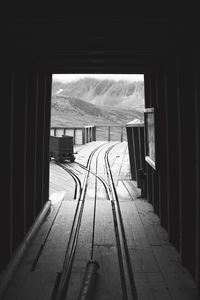 Empty railroad station platform seen through window of building