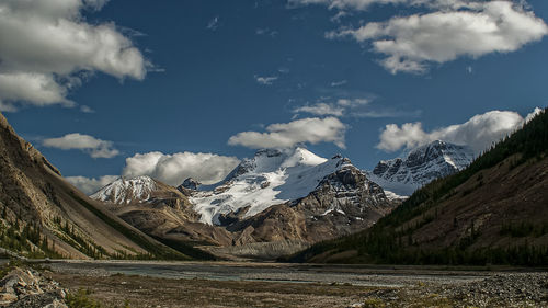 Scenic view of mountains against cloudy sky during winter