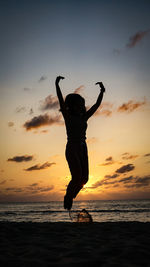 Silhouette man on beach against sky during sunset