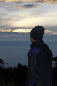 Rear view of man looking at sea against sky