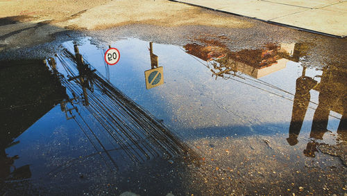 High angle view of road sign on puddle