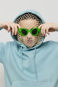 Midsection of woman holding hat against white background