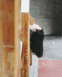 Woman sleeping on bench with head back