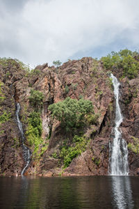 Scenic view of waterfall against sky