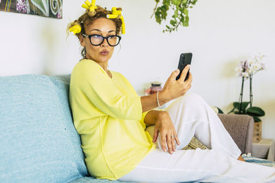 Smiling woman taking selfie sitting at home