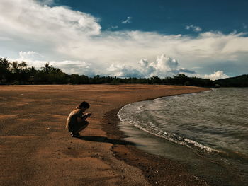 Man crouching at beach