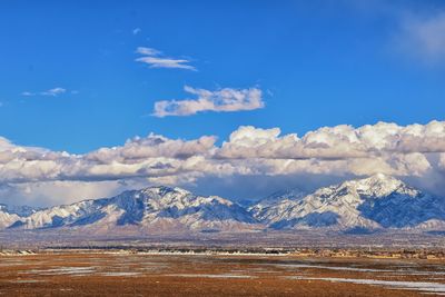 Scenic view of snowcapped mountains against blue sky