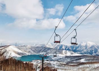 Overhead cable cars against snowcapped mountains and sky