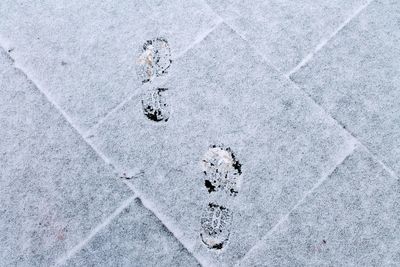 Footprints on snow covered pavement