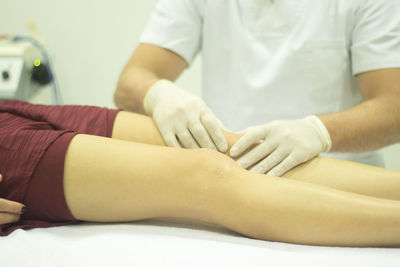 Midsection of physical therapist massaging patient