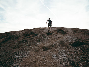 Full length of man climbing on mountain against sky