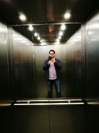 Full length of man standing in illuminated building