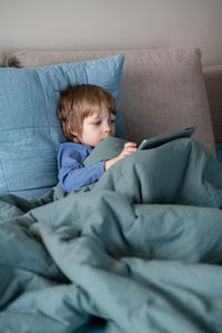 Boy lying on sofa at home