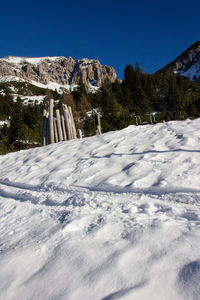 Scenic view of snow covered mountains against clear blue sky