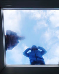 Low angle view of man standing by window