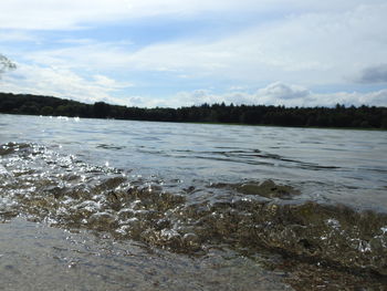 View of calm lake against cloudy sky