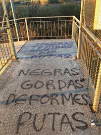 High angle view of text on railing