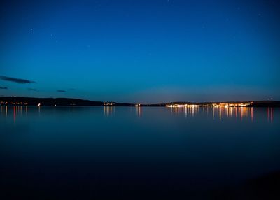 Scenic view of lake against blue sky at night