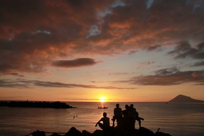 Silhouette of people at beach during sunset