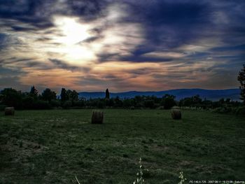 Scenic view of farm against sky during sunset