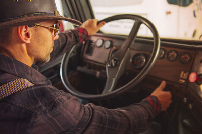 Man wearing sunglasses driving truck