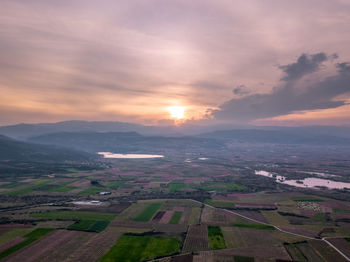 Scenic view of agricultural field against sky during sunset