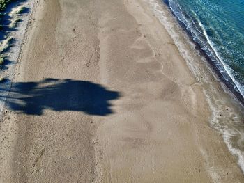 High angle view of shadow on sand at beach