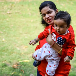 Loving mom carrying of her baby at society park. bright portrait of happy mum holding child