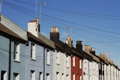 Low angle view of cables over building against sky