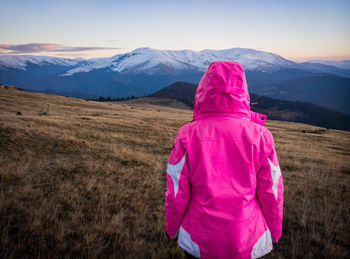 Rear view of woman on field against mountains