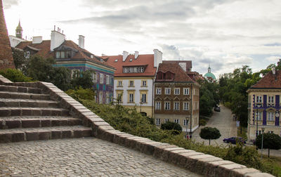 Residential buildings by street against sky