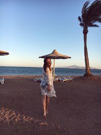 Full length of woman on beach against sky