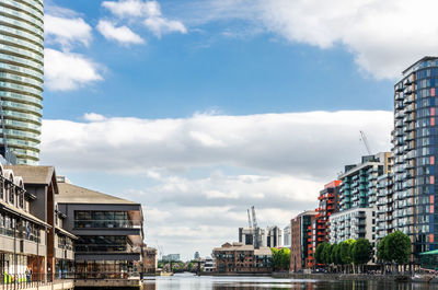 Buildings in city against cloudy sky