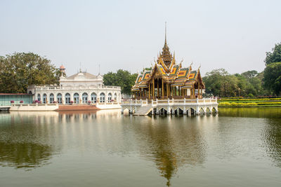 View of building by lake against sky