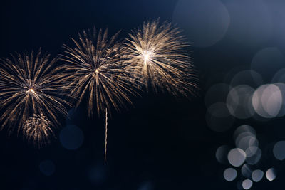 Low angle view of firework display at night