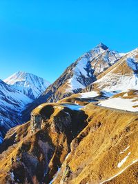 Scenic view of snowcapped mountains against clear blue sky