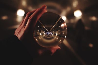 Cropped hand holding crystal ball in tunnel