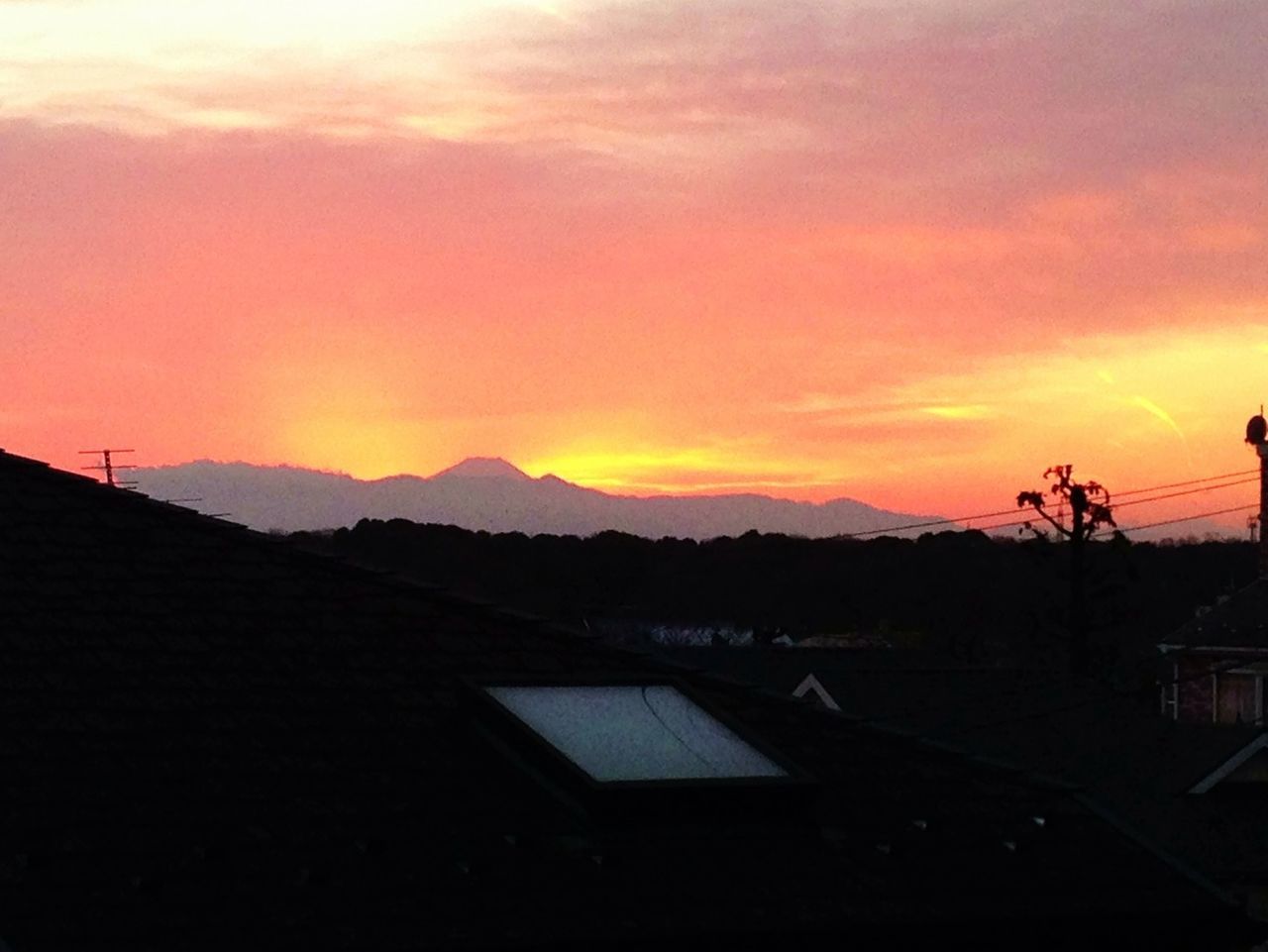 sunset, building exterior, orange color, silhouette, sky, built structure, architecture, house, mountain, beauty in nature, scenics, cloud - sky, landscape, nature, residential structure, tranquil scene, tranquility, cloud, idyllic, outdoors