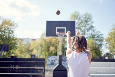 Rear view of woman playing with ball