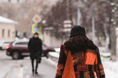 Rear view of woman on street during winter