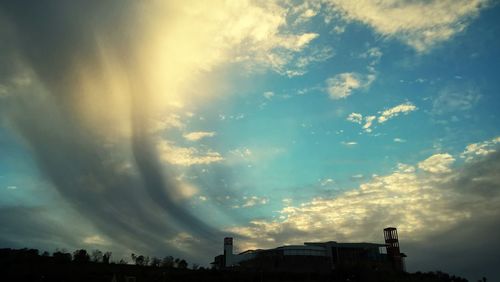 Low angle view of silhouette built structure against sky