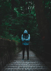 Rear view of man walking on footpath in forest